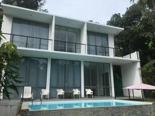 a villa with a swimming pool in front of it at Neilis Villa in Hikkaduwa