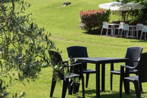 a table and chairs with an umbrella in the grass at Agriturismo Nobile in Montepulciano