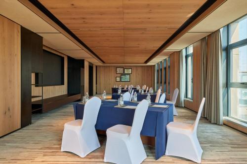 a conference room with a blue table and white chairs at Four Points by Sheraton Nantong, Haimen in Nantong