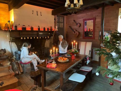 two women in a room with a table with candles at Chambres d'Hotes Au Vieux Logis in Nistos