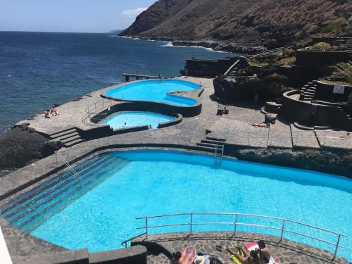 una fila de piscinas junto al océano en Una casa con vistas, en La Caleta