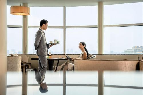 a man and a woman walking in an office at Melia Hanoi in Hanoi