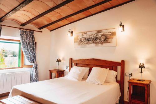 a bedroom with a large white bed and a window at Agroturisme Son Barceló Mas in Campos