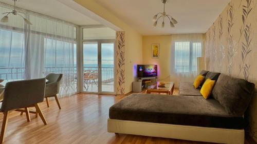 a living room with a bed and a dining room at Beachfront Havana in Sveti Vlas