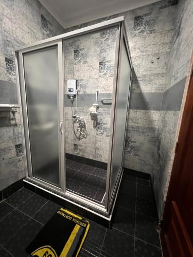 a shower with a glass door in a bathroom at Prayer Mountain Cove in Kampala