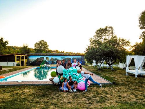 un groupe de personnes avec des ballons à côté d'une piscine dans l'établissement Agrovillage, à Labaşinţ
