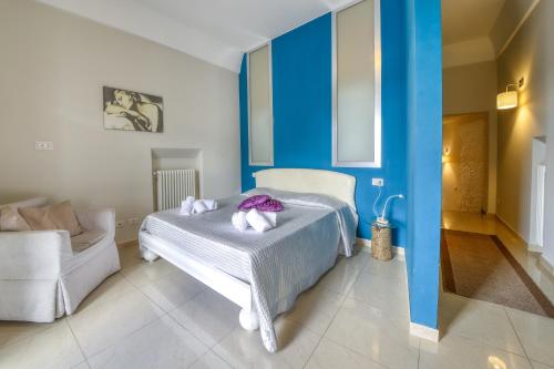 1 dormitorio con paredes azules y 1 cama con toallas. en La Cattedrale Apartments&Suite - Affitti Brevi Italia, en Gravina in Puglia