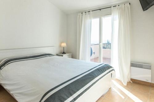 une chambre blanche avec un lit et une grande fenêtre dans l'établissement Bonheur - Vakantiewoning Côte d'Azur, à Roquebrune-sur Argens