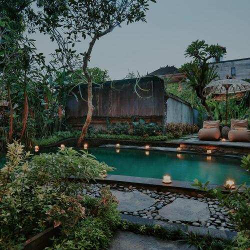 a small pool in a garden with lights at Lastana Suite Joglo Ubud in Ubud