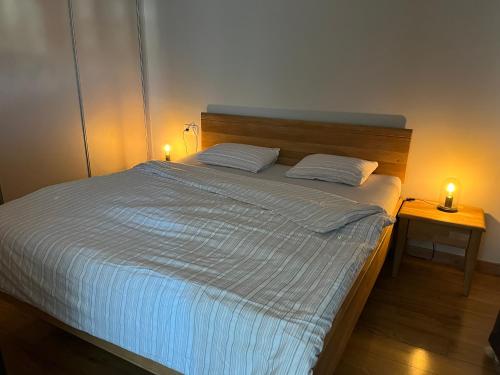 a bedroom with a bed with two lights on it at Apartman Usmev in Košice