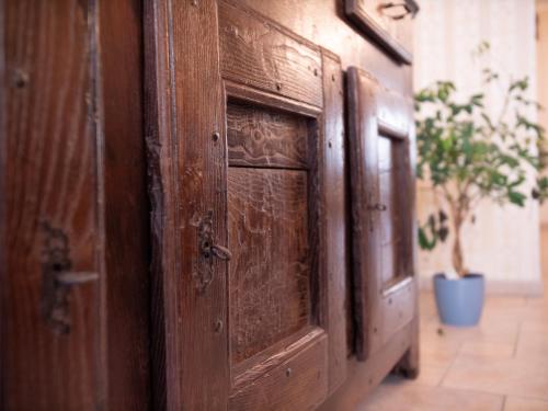 a pair of wooden doors in a room with a plant at Gite les bons amis in Plombières