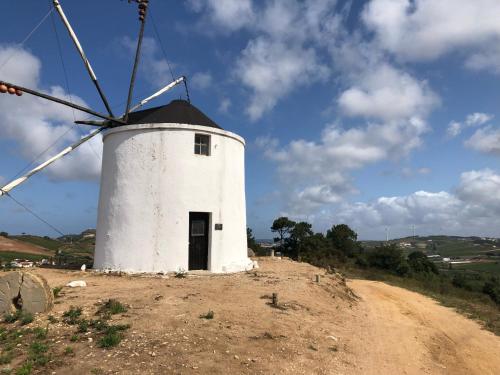 a white windmill on top of a hill at Casa Martins Country Apt, No.6 in Freiria