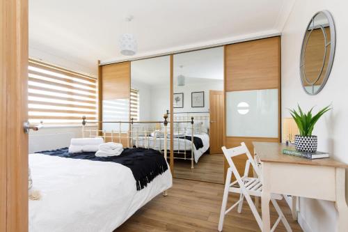 a bedroom with a large bed and a desk and a desk at Charming Bolthole 400m to Beach in Earnley