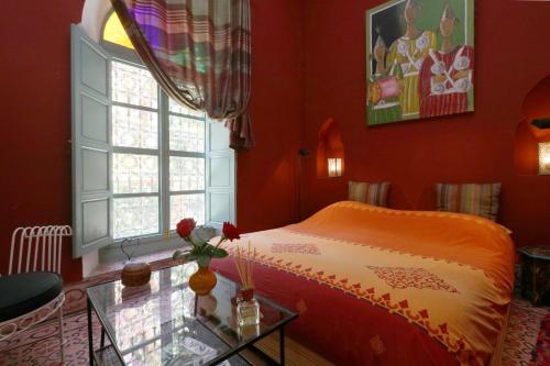 a bedroom with a bed and a window and a table at Ryad El Borj in Marrakech