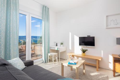 ein Wohnzimmer mit einem Sofa und einem großen Fenster in der Unterkunft Villa Jolara With Pool - Deluxe Suite 6 in Mimice