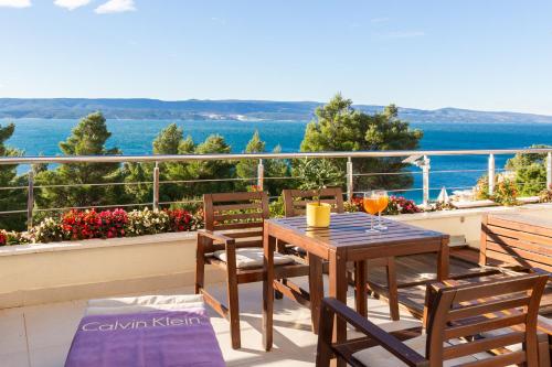 einen Tisch und Stühle auf einem Balkon mit Meerblick in der Unterkunft Villa Jolara With Pool - Deluxe Suite 6 in Mimice