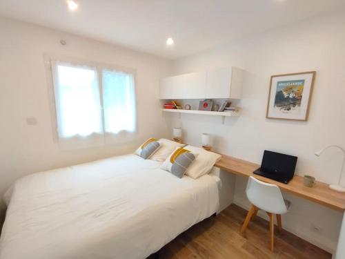 1 dormitorio con 1 cama blanca grande y escritorio en Logement au calme avec jardin proche de Vannes, en Elven