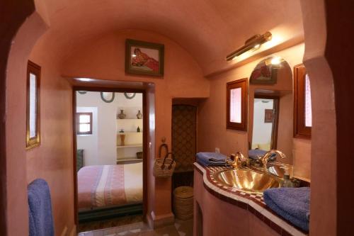 a bathroom with a sink and a bed in a room at Ryad El Borj in Marrakech