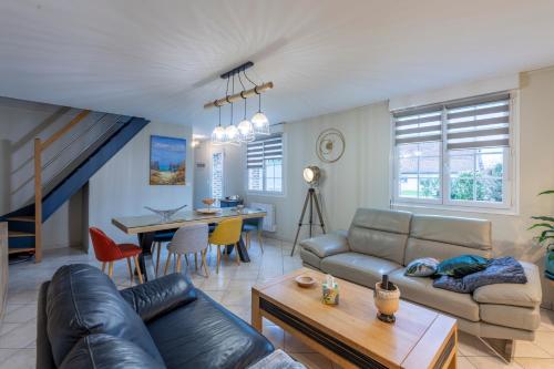 un salon avec un canapé et une table dans l'établissement Les 3 Hirondelles - Maison avec grand jardin, à Bracquemont