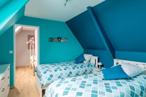 - une chambre bleue avec un lit et des murs bleus dans l'établissement Les 3 Hirondelles - Maison avec grand jardin, à Bracquemont