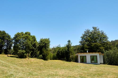 a small house on top of a grassy hill at Casa de campo in Lago Ranco