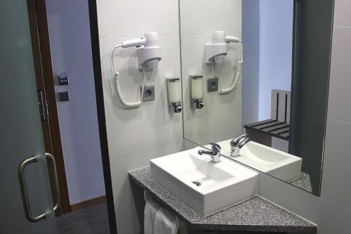 a bathroom with a white sink and a mirror at Hotel M in Espinho