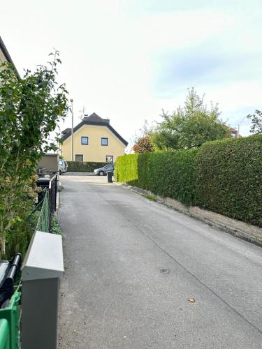 an empty street with a house and a hedge at The Peaceful Garden Stay & Free Parking in Salzburg