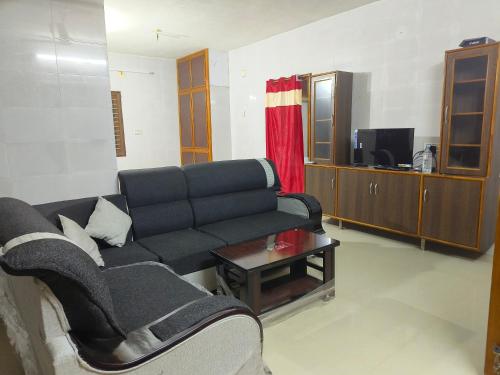 a living room with a couch and a tv at V1 Stay Home in Tirupati