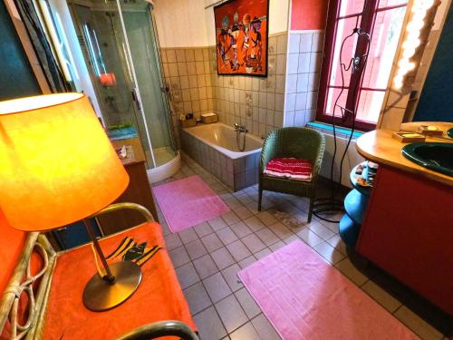 La salle de bains est pourvue d'une baignoire, d'une chaise et d'un lavabo. dans l'établissement Maison de ferme, prairies sur la colline, étang, à Lanuéjouls-et-Privezac