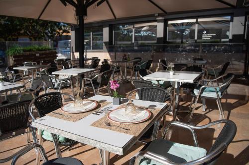 a group of tables and chairs in a restaurant at Hotel Palau de Girona in Sant Julià De Ramis