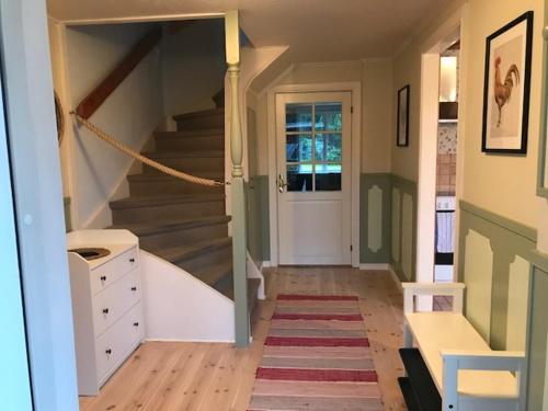 a hallway with a staircase leading to a door at schwedischer Waldhof -Marie- in einsamer Lage in Åmål