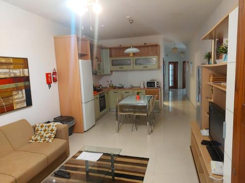 sala de estar y cocina con sofá y mesa en Swieqi Apartment, en San Julián