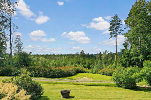 a park with a bench in the middle of a field at schwedischer Waldhof -Marie- in einsamer Lage in Åmål