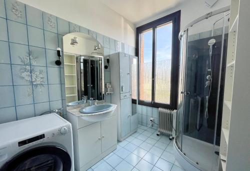 a bathroom with a sink and a washing machine at En route pour disney et shopping a la vallée village in Couilly-Pont-aux-Dames