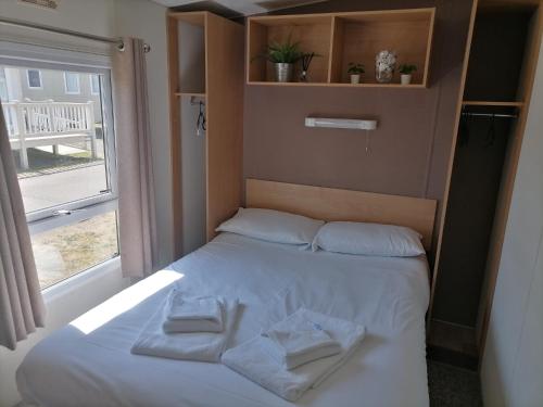 Una cama en una habitación con dos toallas. en New Beach Holiday Park, en Kent