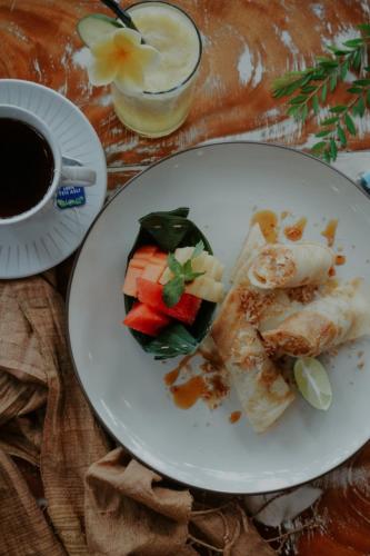 a plate of food on a table with a cup of coffee at Lastana Suite Joglo Ubud in Ubud