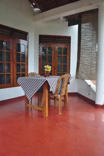 una mesa de comedor con sillas y un jarrón de flores. en Sea Breeze Inn Talalla en Talalla South
