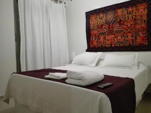 a bed with two towels and a remote control on it at Dpto doña coca alto villasol gama in Cordoba