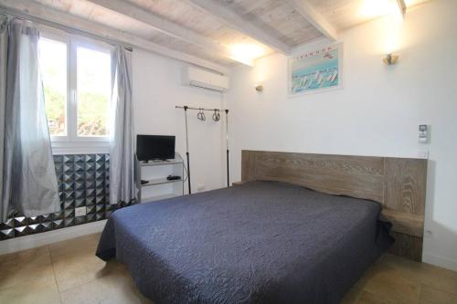 une chambre avec un lit, une fenêtre et une télévision dans l'établissement GASJOU - Golfe de St-Tropez - Gassin - Mazet pour 6 personnes dans domaine avec piscine et tennis, à Gassin