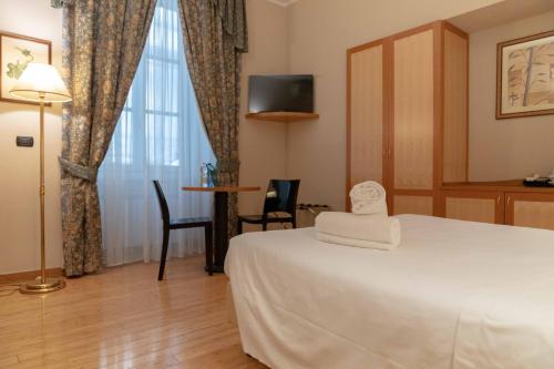 a hotel room with a bed and a window at Hotel Bologna in Turin