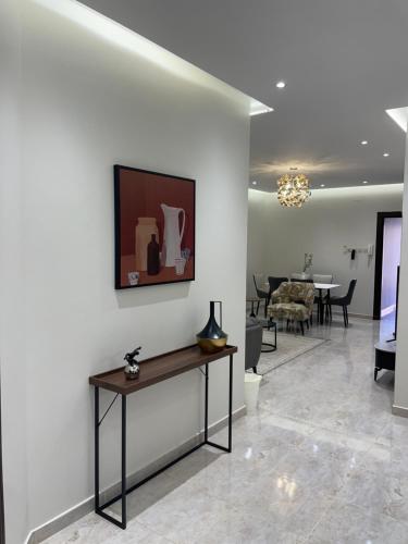 a living room with a table on a wall at شقق مسك الفندقية MISK Apartments in Riyadh Al Khabra