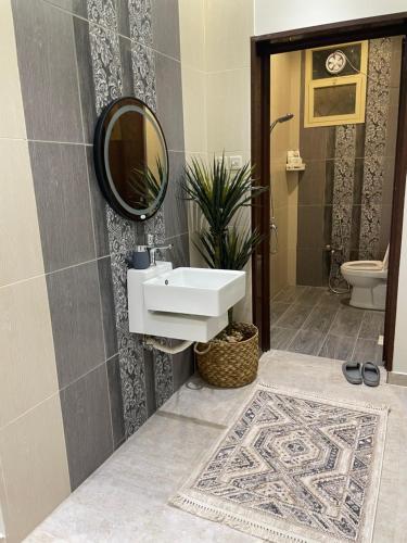 a bathroom with a sink and a mirror at شقة فاخرة للعوائل دور ارضي مع فناء خارجي in Riyadh Al Khabra