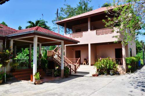 a house on the beach with a person sitting in the doorway at Heimat Garden in Ban Lo Pa Ret