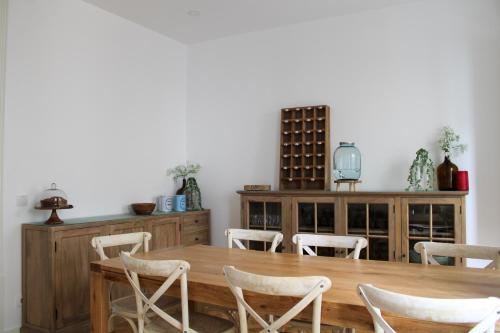 Casa dos Cucos في إيريسييرا: غرفة طعام مع طاولة وكراسي خشبية