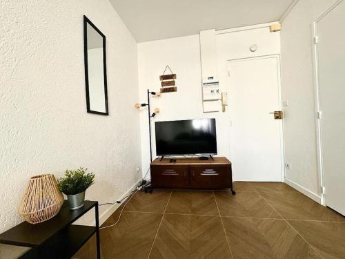 a living room with a flat screen tv and a door at Très grand studio à deux pas de la place de Jaude Puits Artesien in Clermont-Ferrand