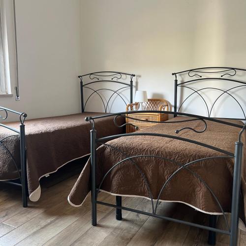 2 nebeneinander sitzende Betten in einem Schlafzimmer in der Unterkunft Appartamenti in Villa in Pulsano