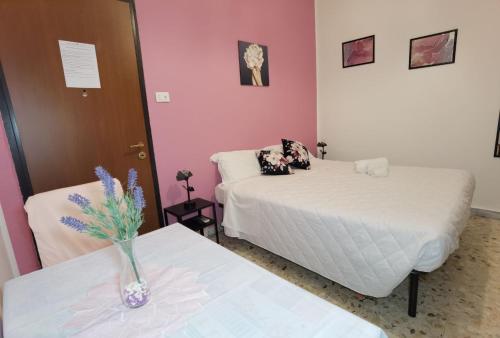 um quarto com duas camas e um vaso de flores em duas mesas em Luxury Sisters House "La Buganvilla" em Catânia