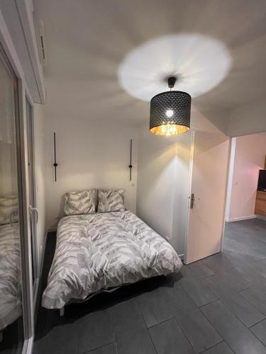 ein Schlafzimmer mit einem großen Bett und einer Lampe in der Unterkunft Superbe logement Paris Stade de France in La Courneuve