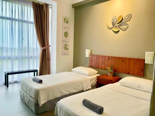 a hotel room with two beds and a butterfly on the wall at Melaka Relax Home - 6 pax - SeaView corner unit - 6 min to Historical Spot & Jonker in Melaka