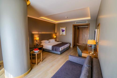 une chambre d'hôtel avec un lit et un canapé dans l'établissement Holiday Inn Bursa - City Centre, an IHG Hotel, à Bursa